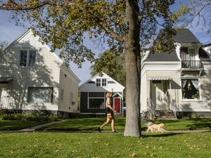 (Leah Hogsten  |  The Salt Lake Tribune) A woman walks her dog along Harvey Milk Boulevard (900 South) and 600 East, just north of Liberty Park in 2020. A plan to put more affordable homes in Salt Lake City neighborhoods is headed to the City Council.